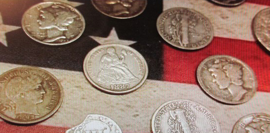 Old coins laid out on an American flag